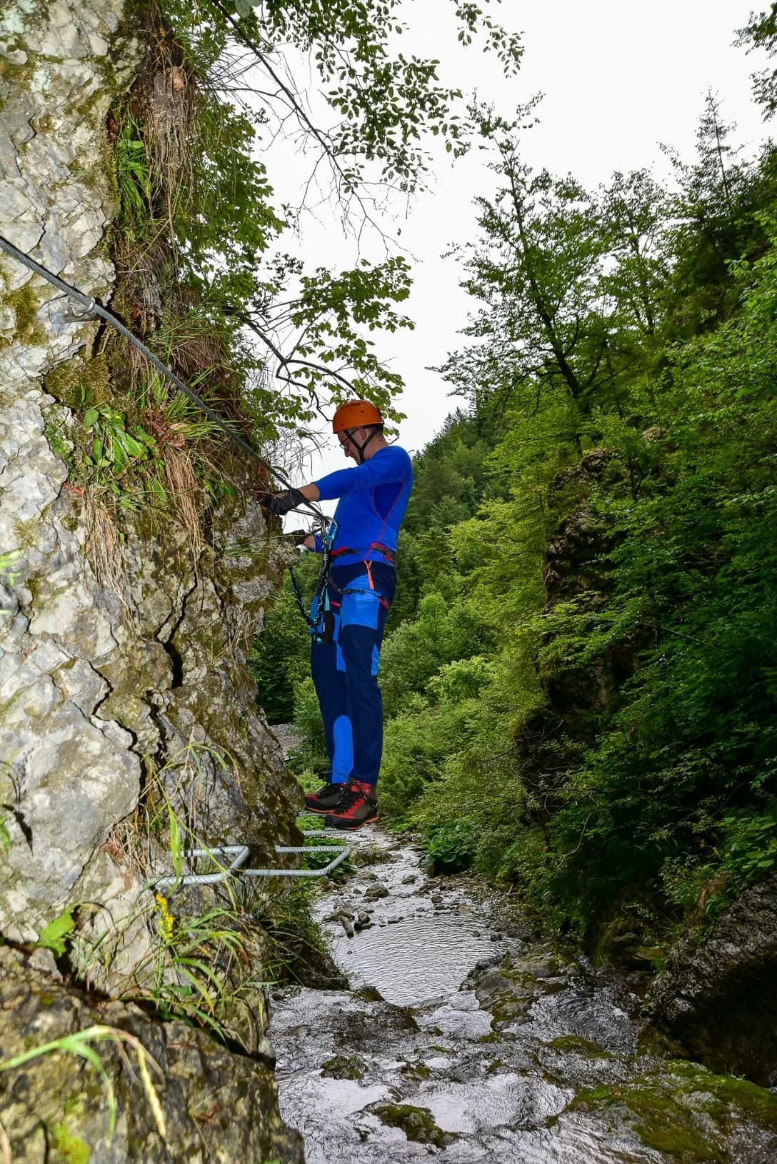 Lezec s přilbou na skalní stěně