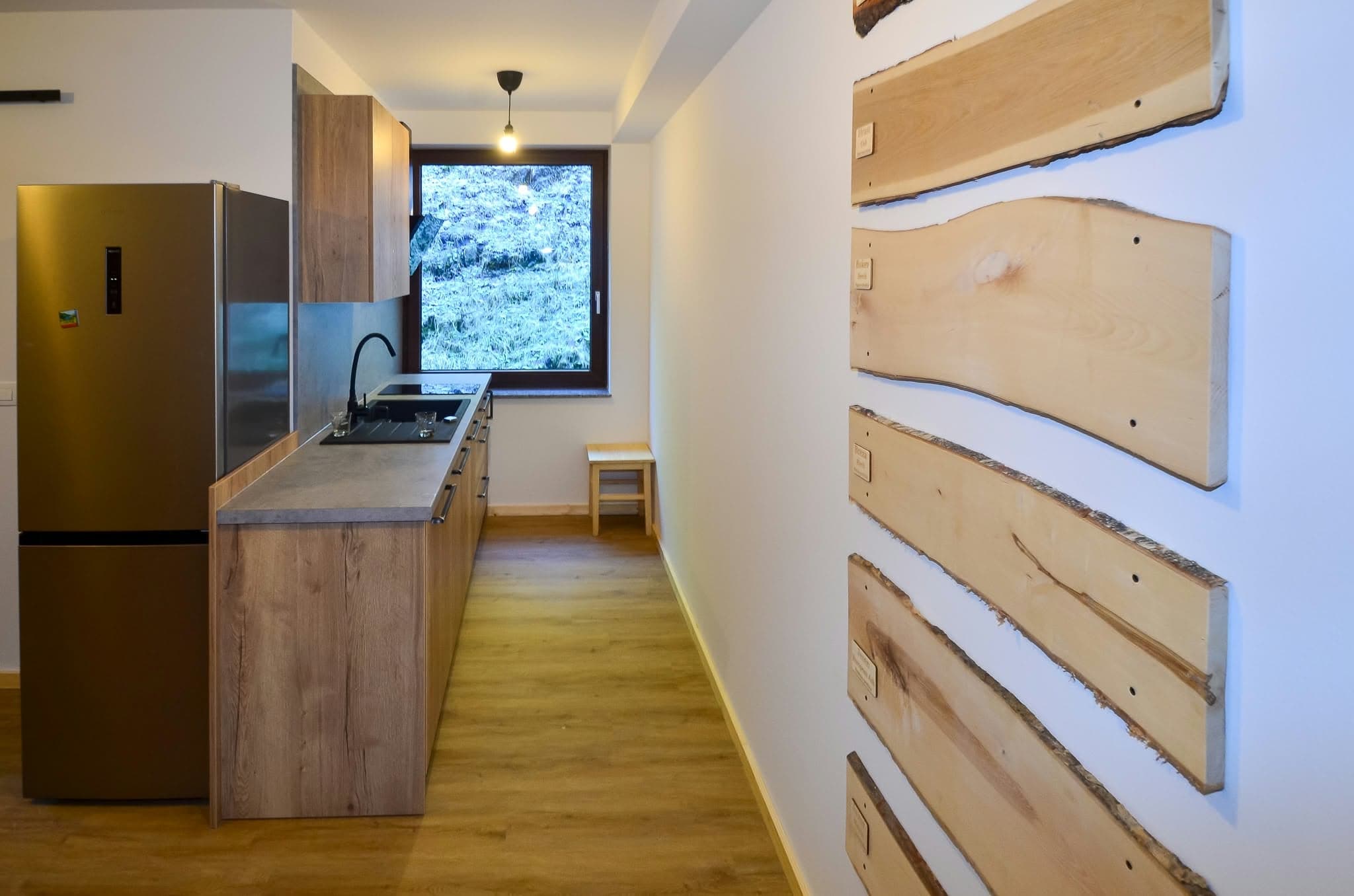 Apartmán 1: Kuchyně s dřevěnými prvky a ozdobnou dřevěnou stěnou