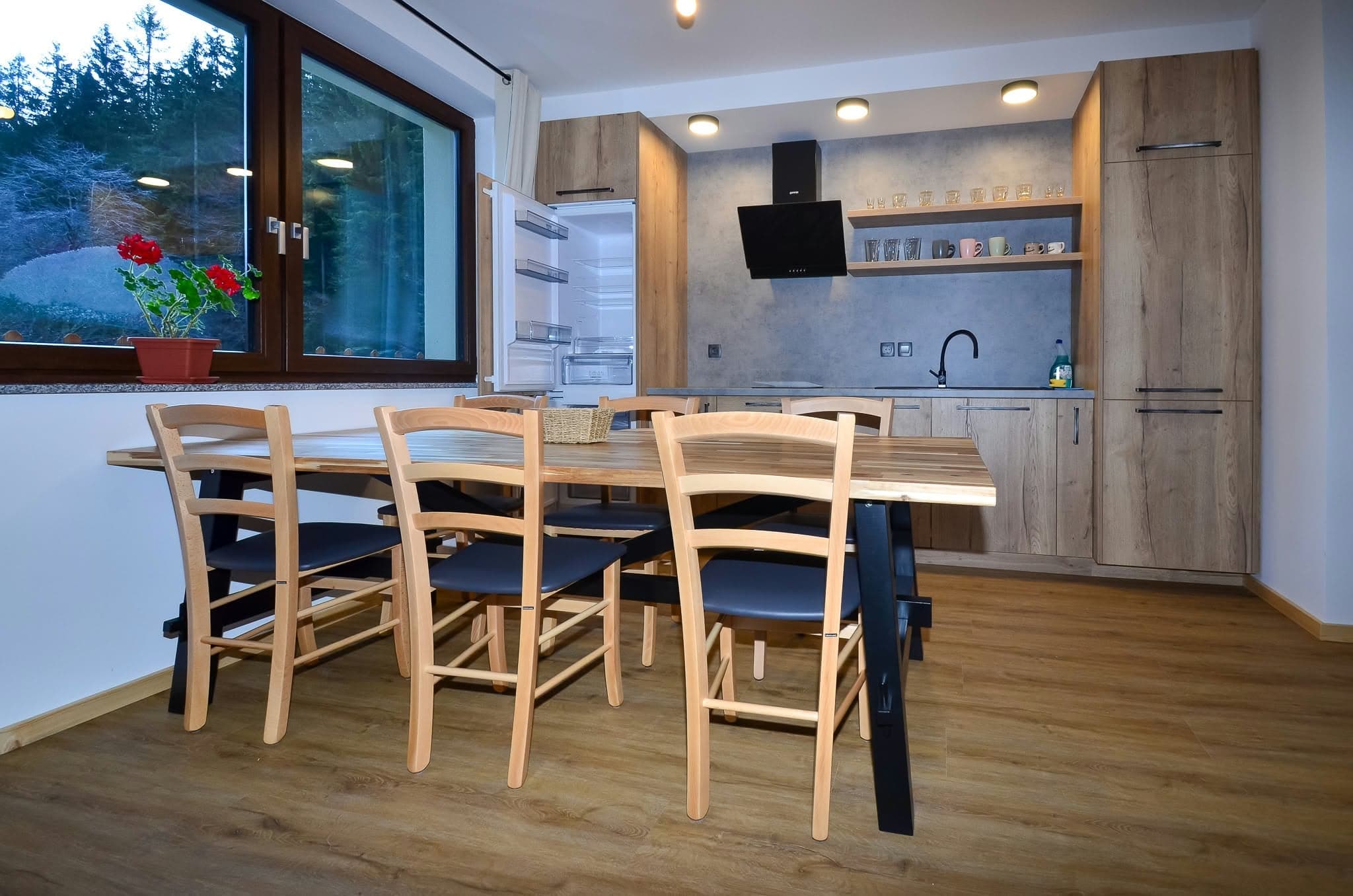 Apartmán 2: Jídelní kout s dřevěným stolem a kuchyň
