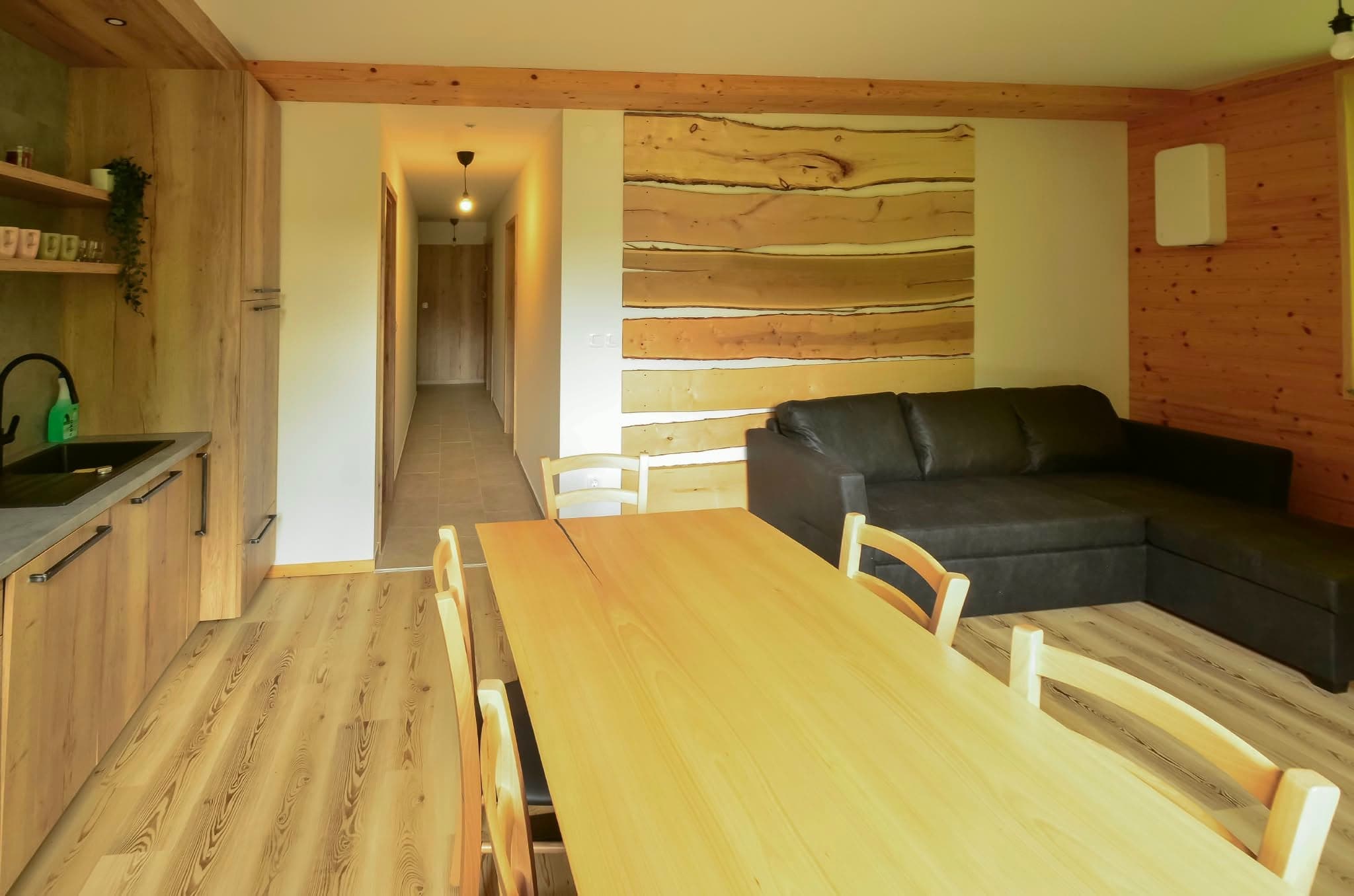 Apartmán 5: Obývací pokoj s dřevěným jídelním stolem